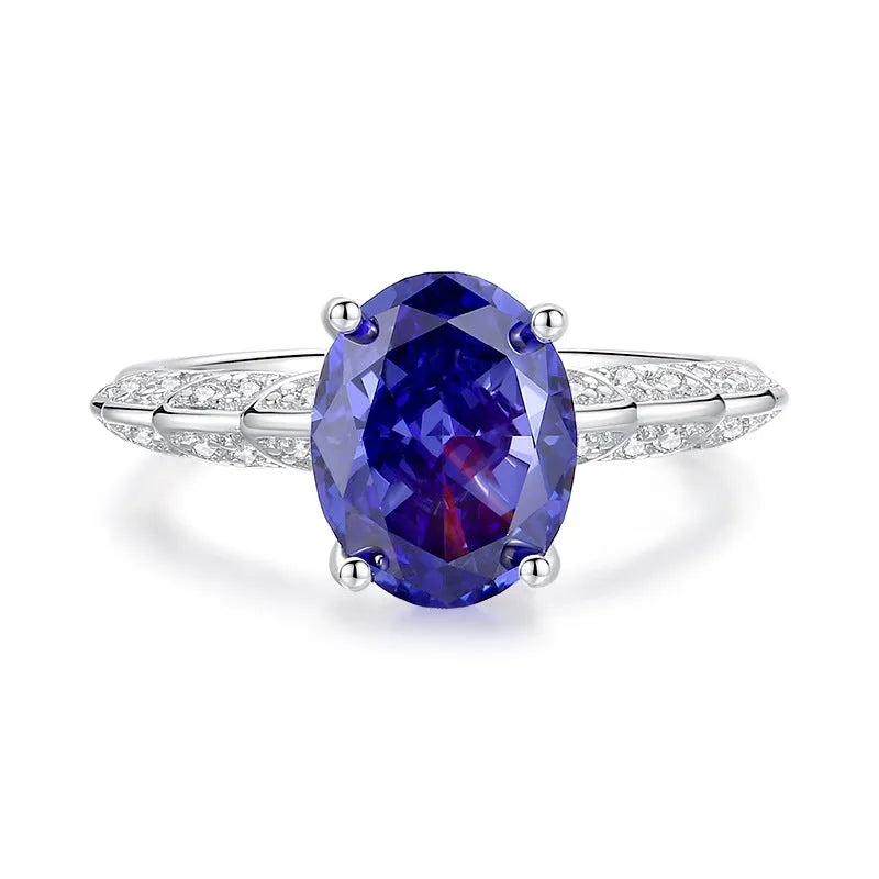 Heart-shaped 925 sterling silver ring with a sparkling ice flower cut colour zircon stone on a finger.