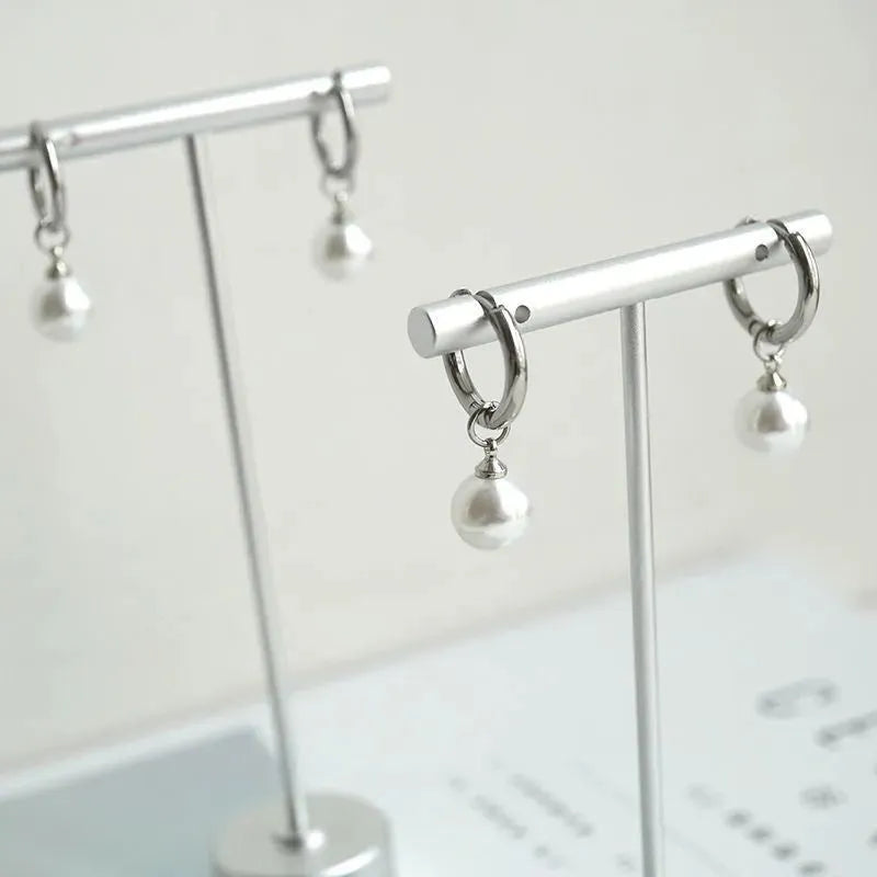 A pair of women's geometric drop earrings with a round pearl detail on alloy hooks.