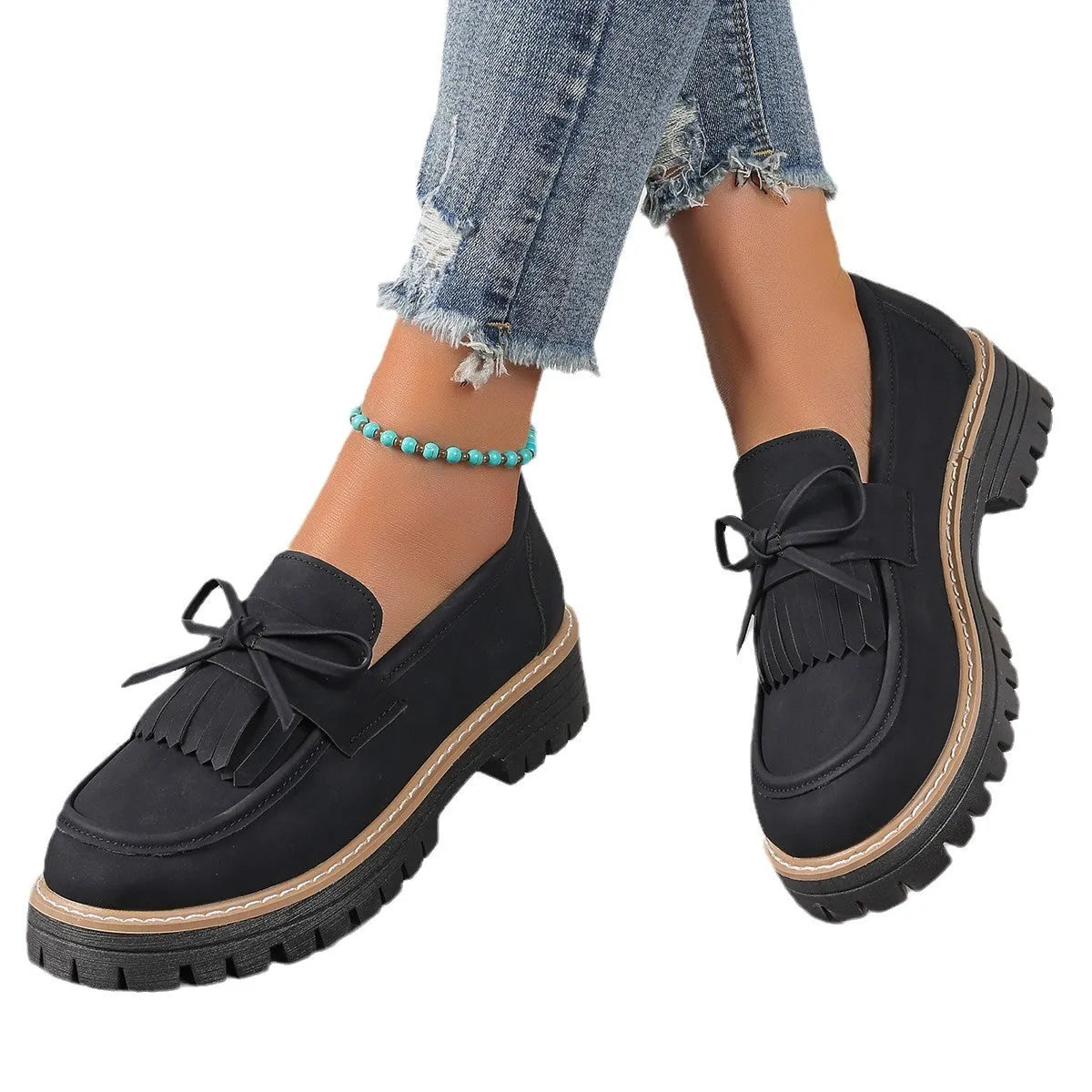 Plus size black women's loafers with tassel detail, bowknot, and a chunky rubber sole.