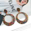 A pair of large round colourful metal pendant earrings in a cartoon style for women.
