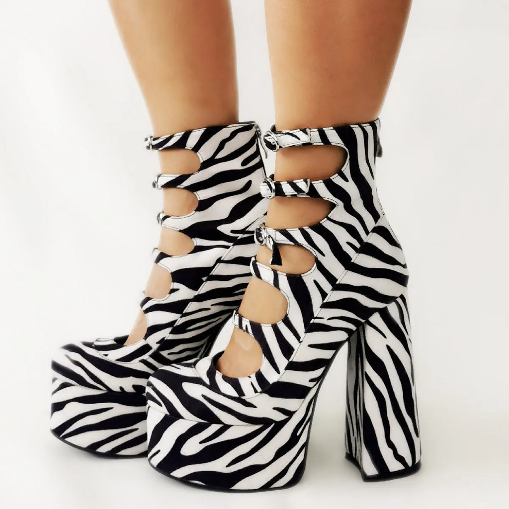 Women's black patent leather platform high heel boots with a thick heel and silver buckle fastening.