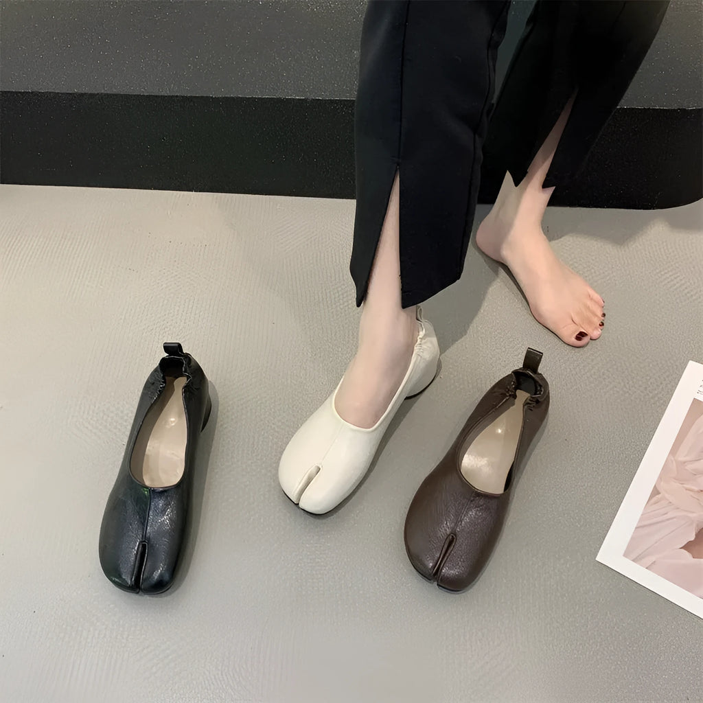 Women's black chunky heel pumps with a unique split toe horseshoe peas design and a low rubber sole.