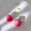 Small and large acrylic peach fruit earrings with copper hooks showing realistic peach detailing