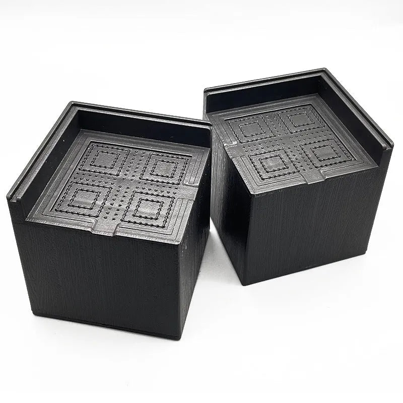 Four black plastic bed risers for raising furniture height with thickened support mats