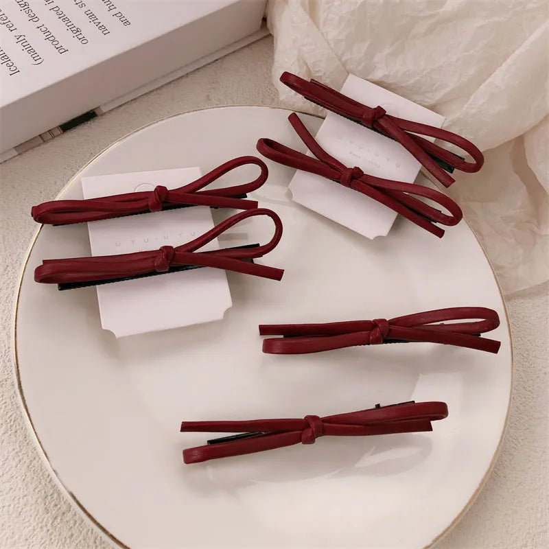 Wine red leather bow barrette hair accessory showing manual craftsmanship and clip mechanism