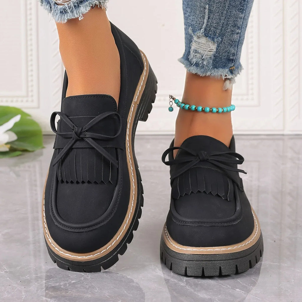 Plus size black women's loafers with tassel detail, bowknot, and a chunky rubber sole.
