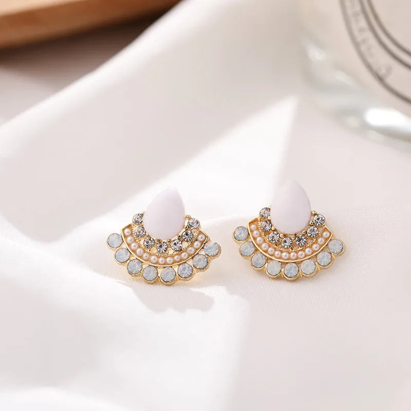 Silver fan-shaped geometric stud earrings with rhinestone detailing on white background