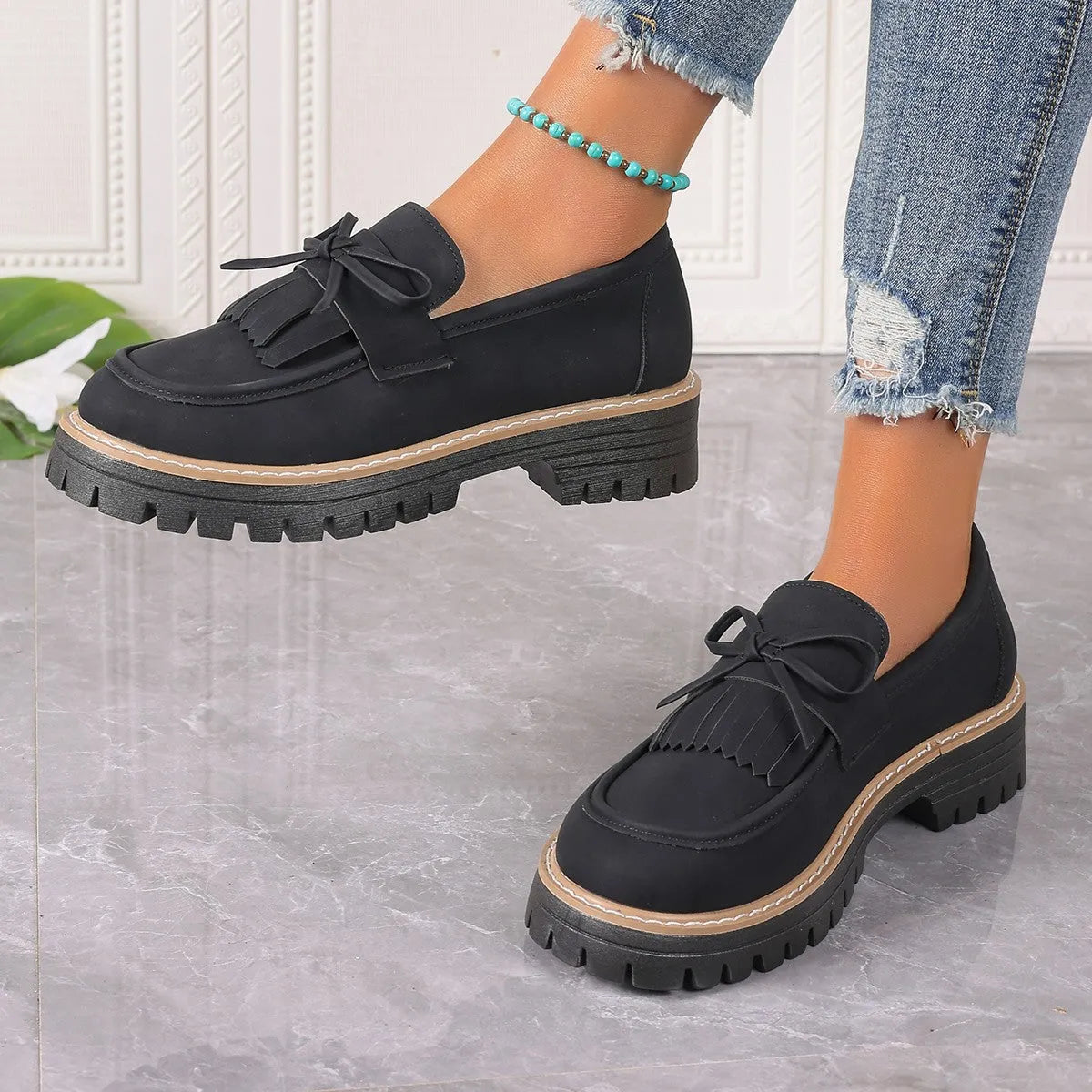 Plus size black women's loafers with tassel detail, bowknot, and a chunky rubber sole.