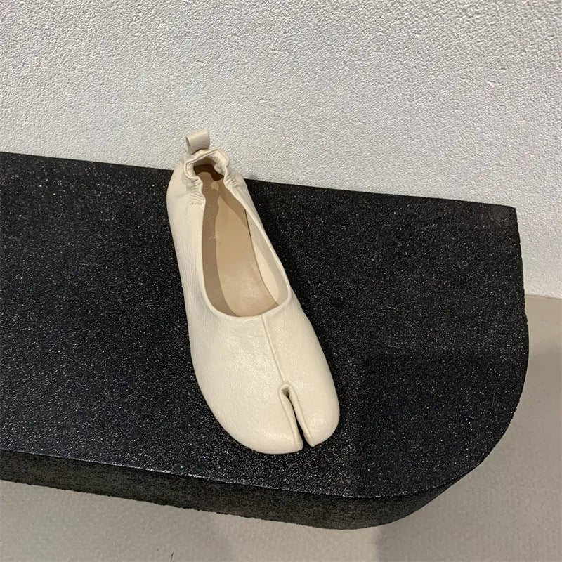 Women's black chunky heel pumps with a unique split toe horseshoe peas design and a low rubber sole.