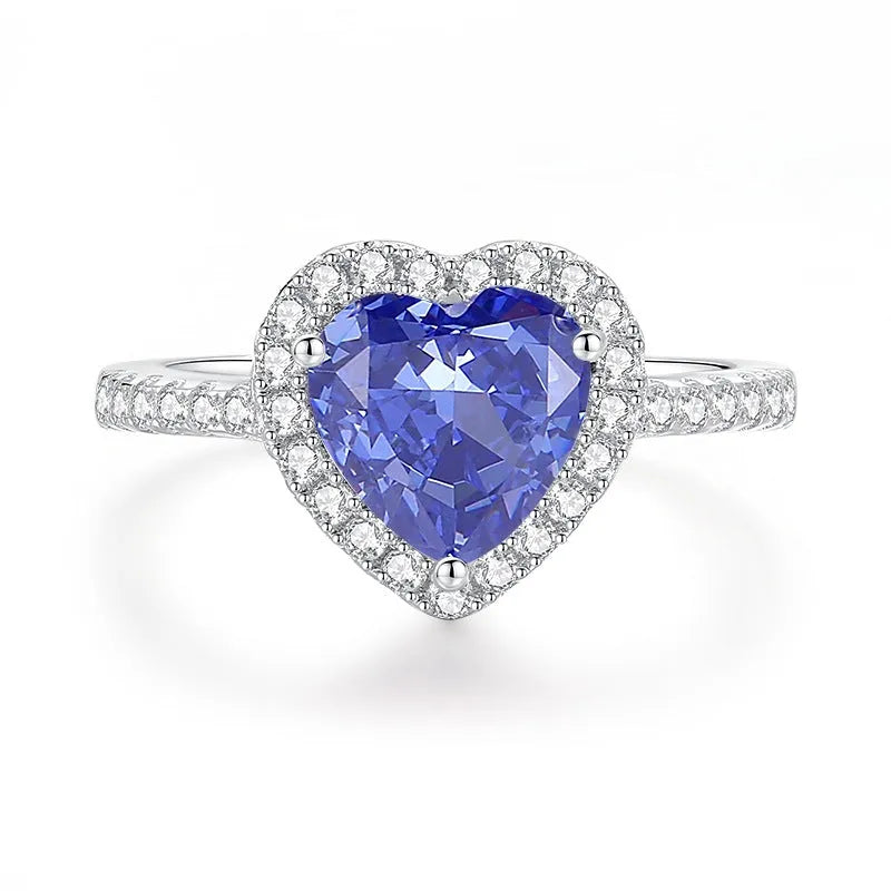 Heart-shaped 925 sterling silver ring with a sparkling ice flower cut colour zircon stone on a finger.