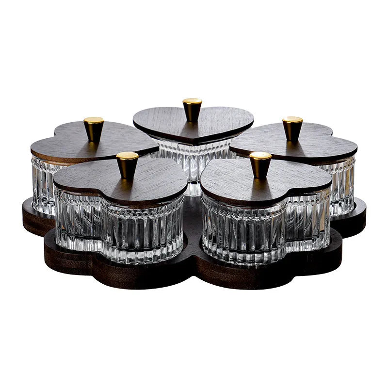 Clear glass serving platter with heart-shaped compartments and a transparent lid on a table.