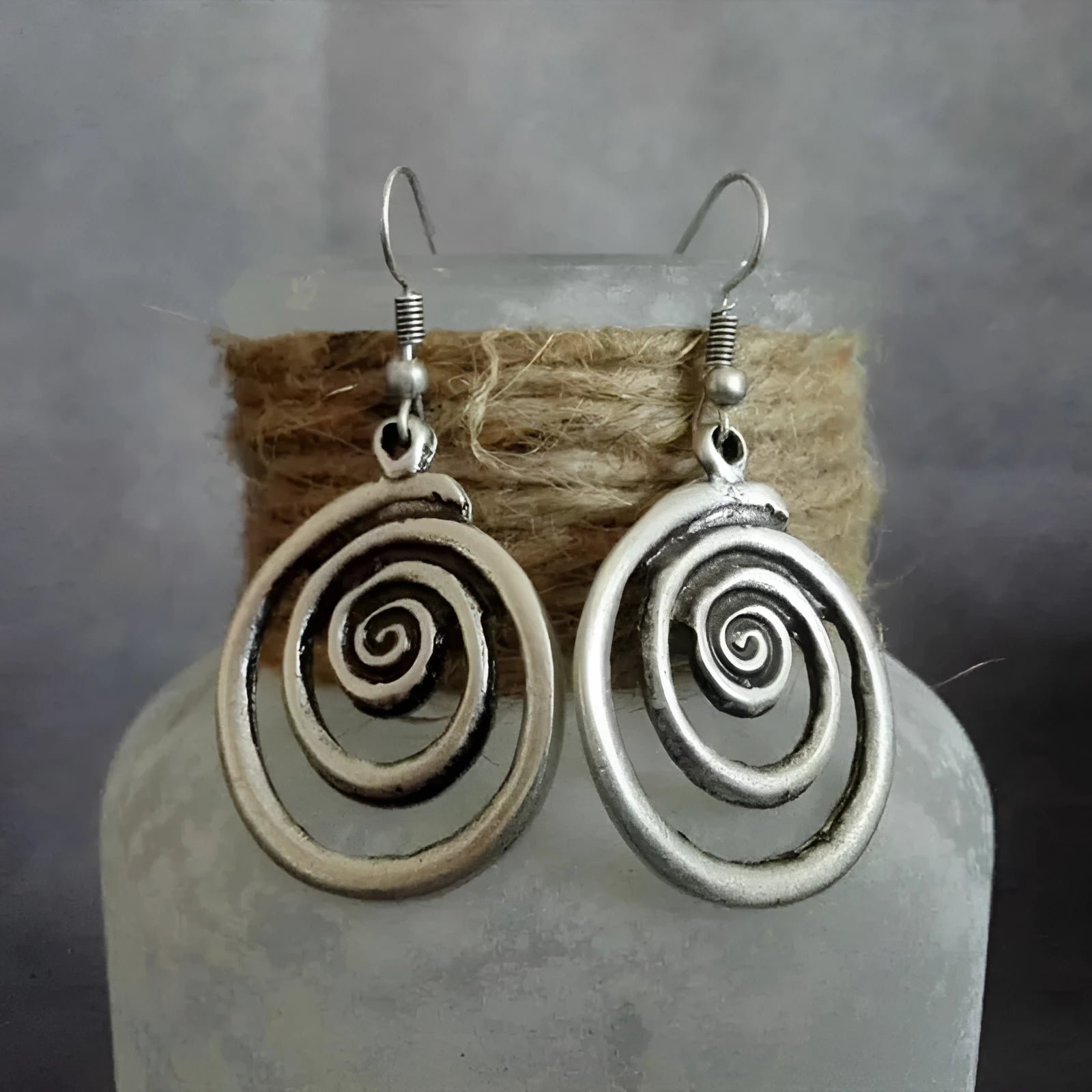 Silver geometric spiral distressed earrings measuring 2.6cm by 5cm with alloy construction