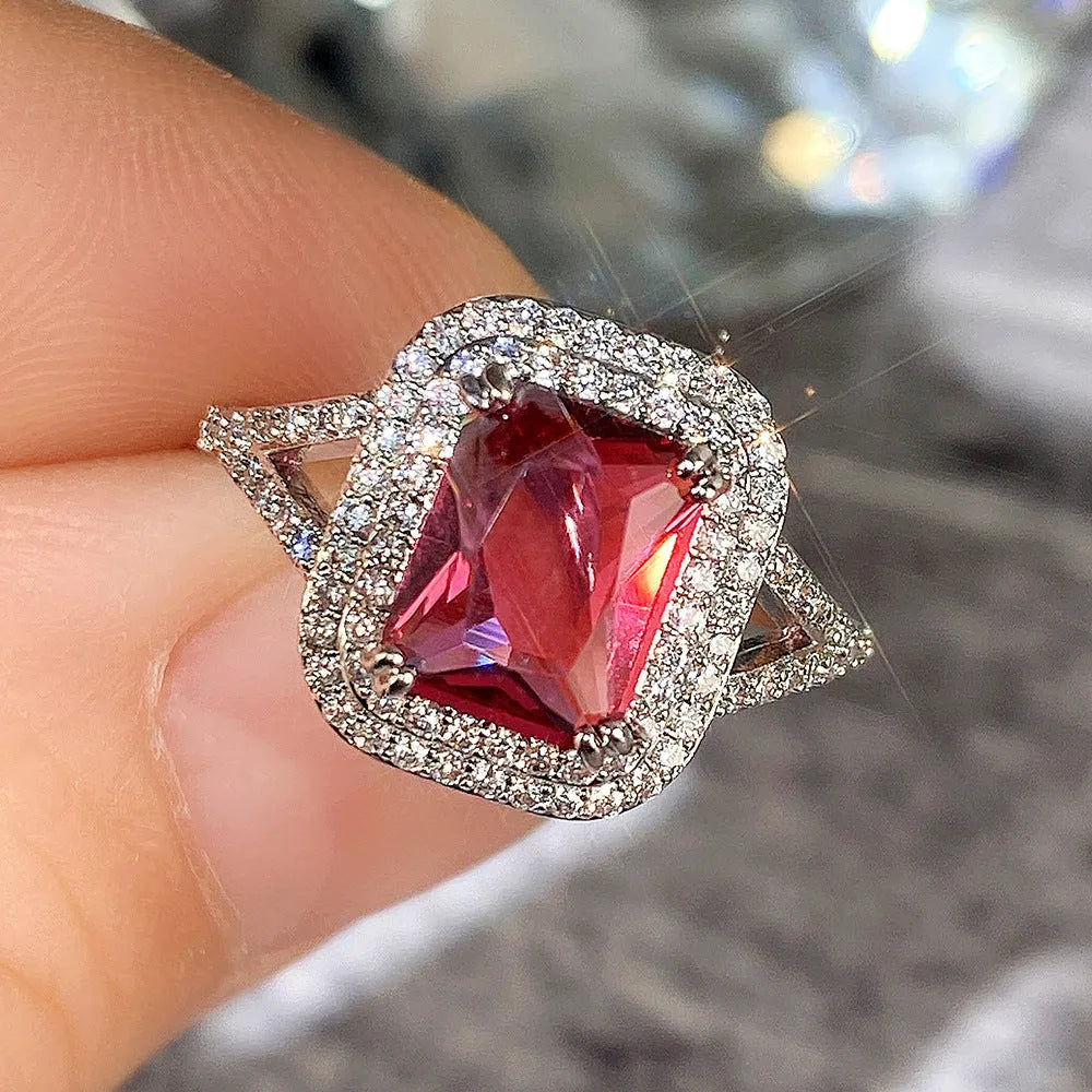 Geometric square copper women's ring with a red rhinestone, shown on a finger.
