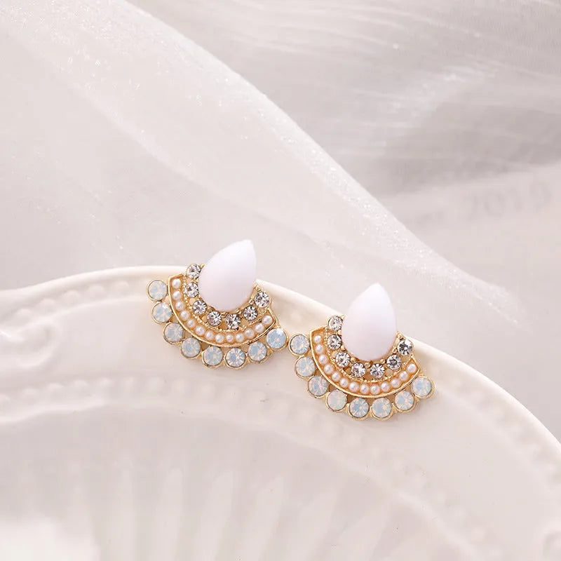 Silver fan-shaped geometric stud earrings with rhinestone detailing on white background