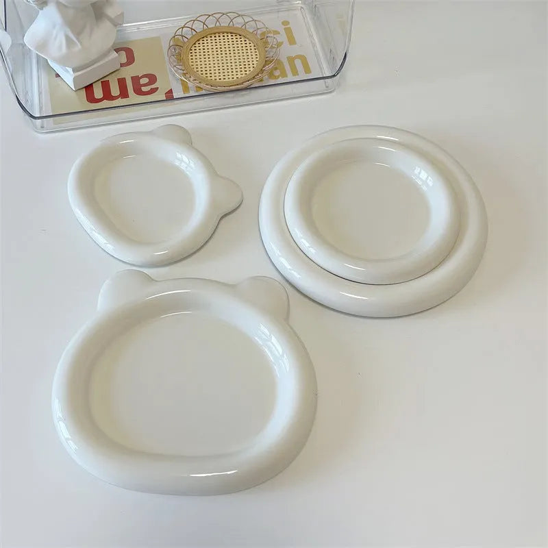 White ceramic plate with black hand-drawn doodle design, shown in bear and round patterns.