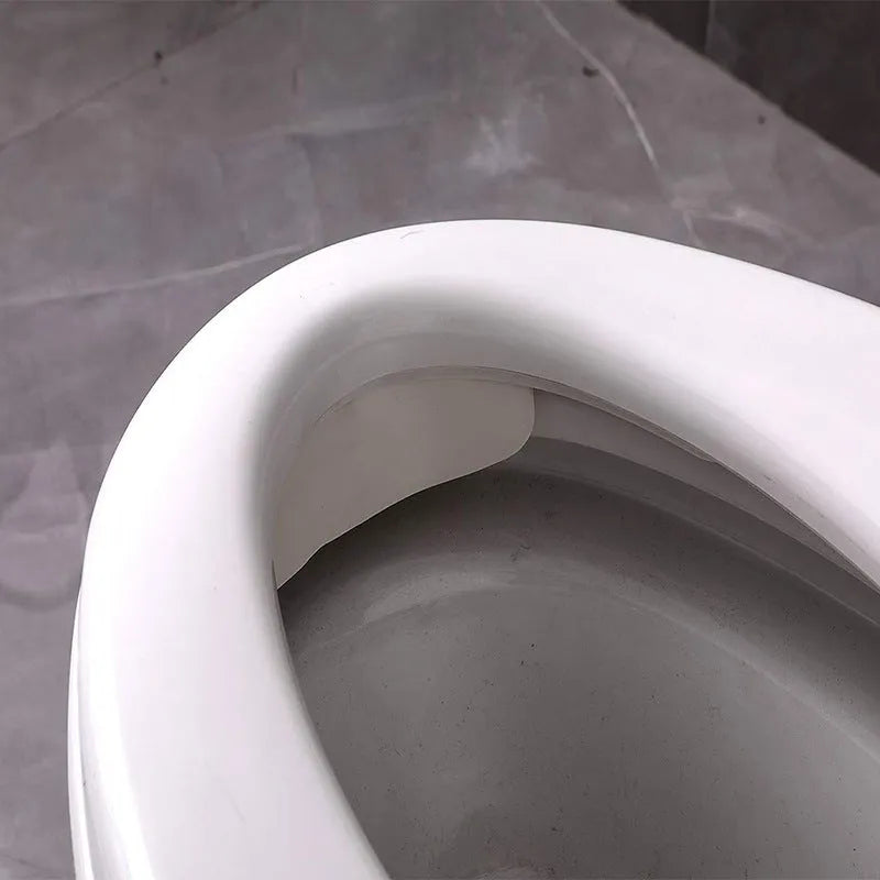 White PVC urine blocking board for children's toilet training placed on toilet