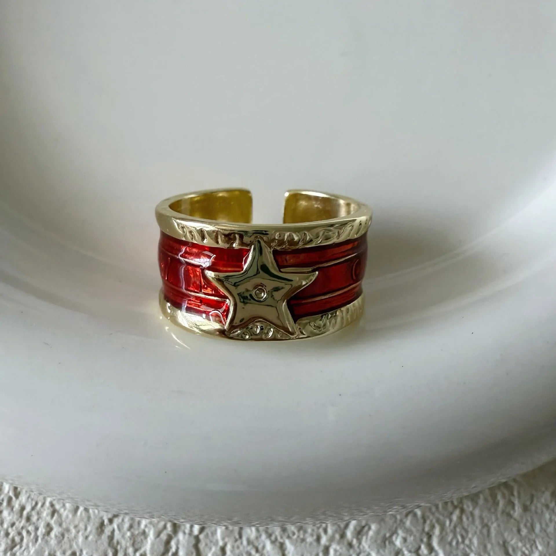Adjustable geometric drop oil ring in distressed electroplated copper on a hand.
