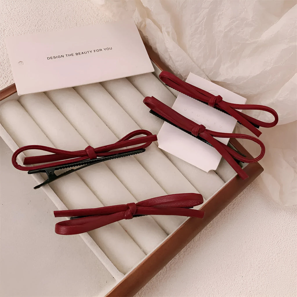 Wine red leather bow barrette hair accessory showing manual craftsmanship and clip mechanism