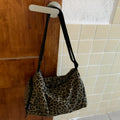 Leopard print sports style messenger bag with cross-body strap and decorative stitching