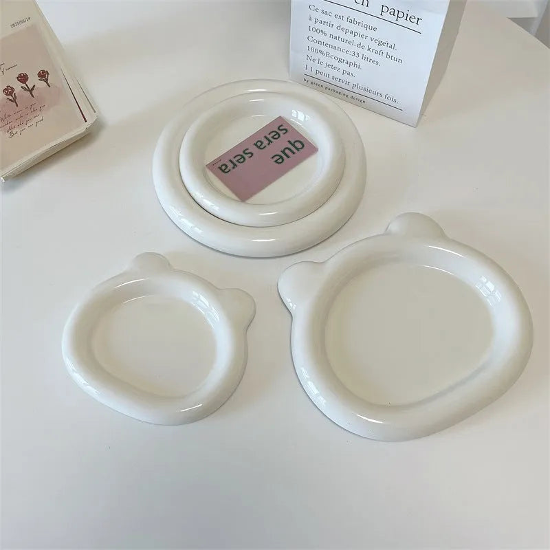 White ceramic plate with black hand-drawn doodle design, shown in bear and round patterns.