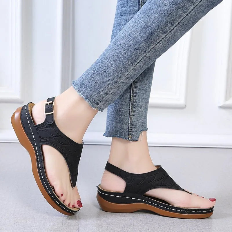 Women's wedge heel flip flop sandals with an adjustable back buckle strap in black.