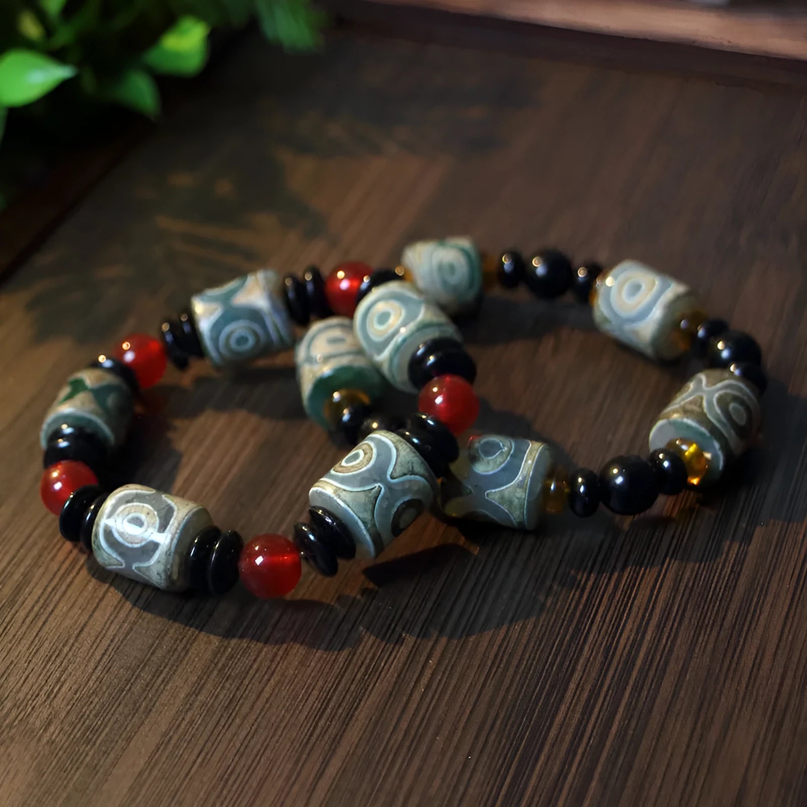Distressed agate Tibet bead bracelet with three-eye motifs and multiple traditional bead styles on wrist