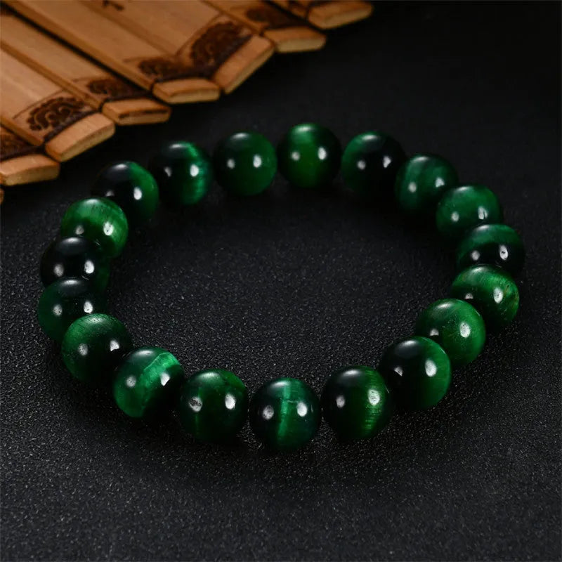 Green tiger eye stone bracelet with geometric beads in various sizes on wrist