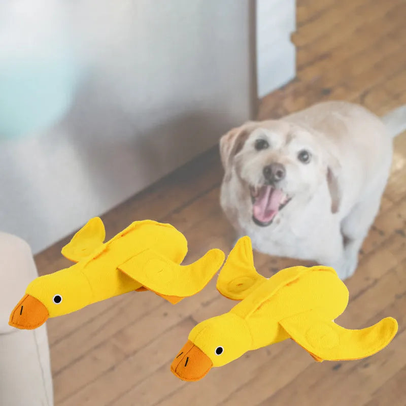 Yellow plush dog toy with attached rubber duck and a treat slot on a white background.