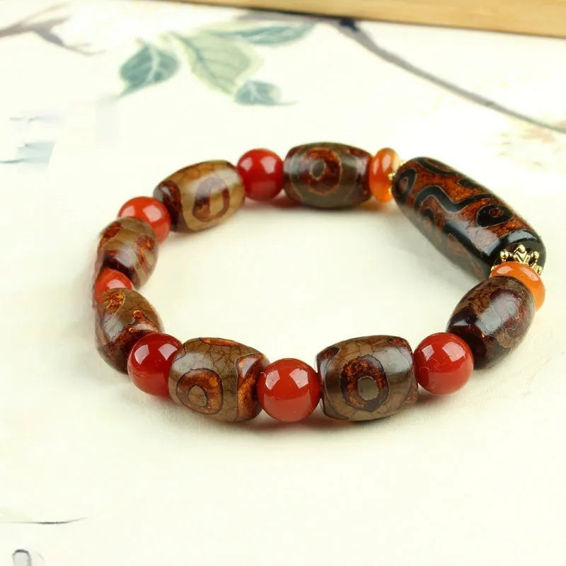 Distressed agate Tibet bead bracelet with three-eye motifs and multiple traditional bead styles on wrist