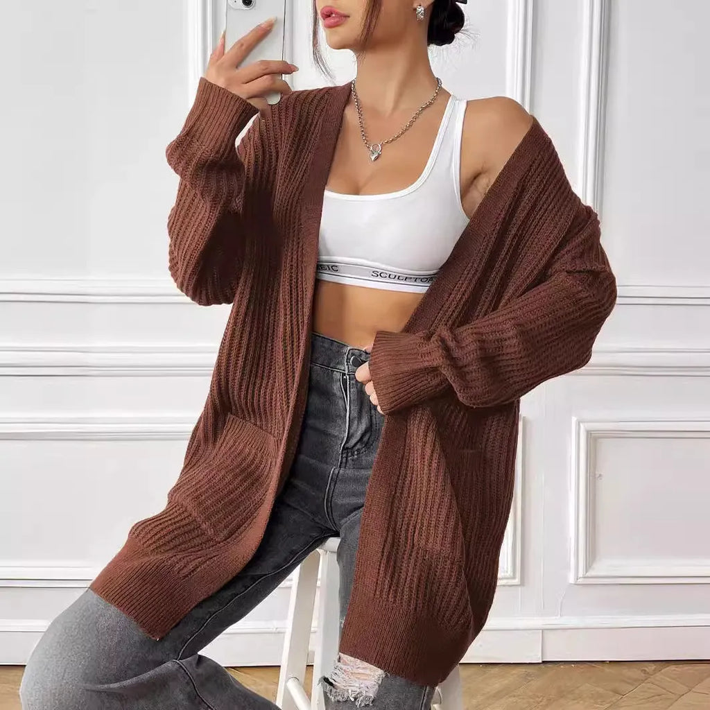 Women's dark green loose fit acrylic cardigan sweater with double pockets and long sleeves.