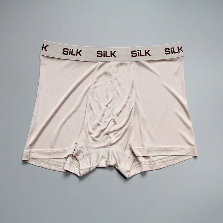 Man wearing loose-fit navy blue silk shorts with a mid waist design.