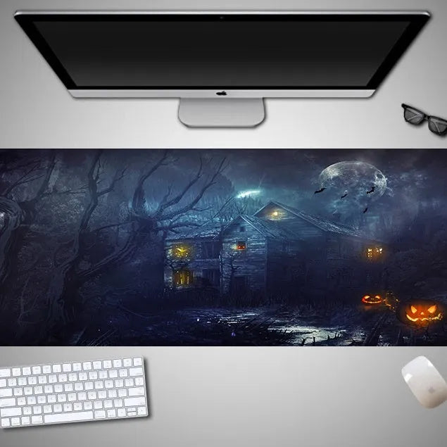 Oversized rectangular Halloween-themed mouse pad on a desk, showing non-slip rubber cloth base.