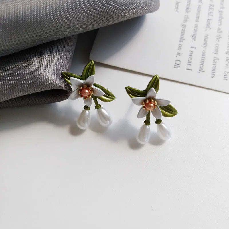Women's alloy earrings set showing flower studs and camellia ear clip in contrasting colours