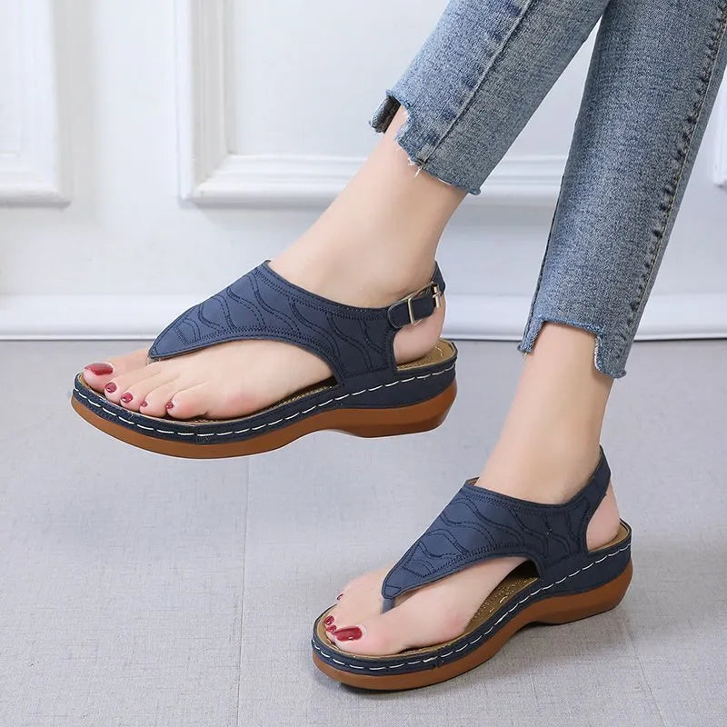 Women's wedge heel flip flop sandals with an adjustable back buckle strap in black.