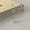 Women's silver necklace with large round geometric stone pendant on a curb chain.