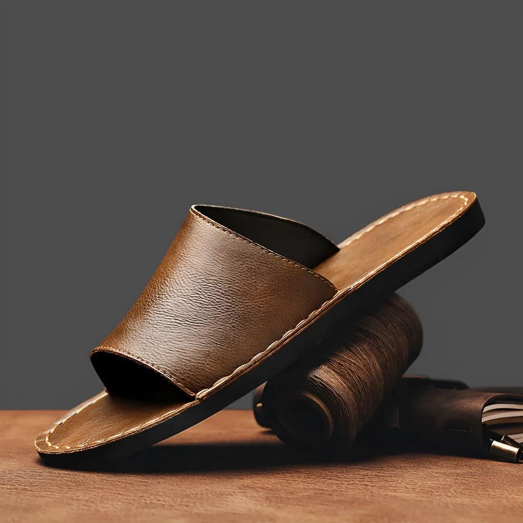 Brown and black men's outdoor leather sandals with rubber soles on a neutral background.