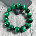 Green tiger eye stone bracelet with geometric beads in various sizes on wrist