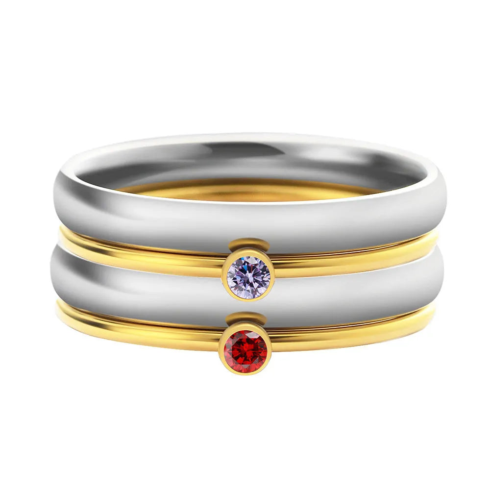 Close-up of a geometric titanium steel ring with an engraved superimposed pattern, shown in a December birthstone colour.