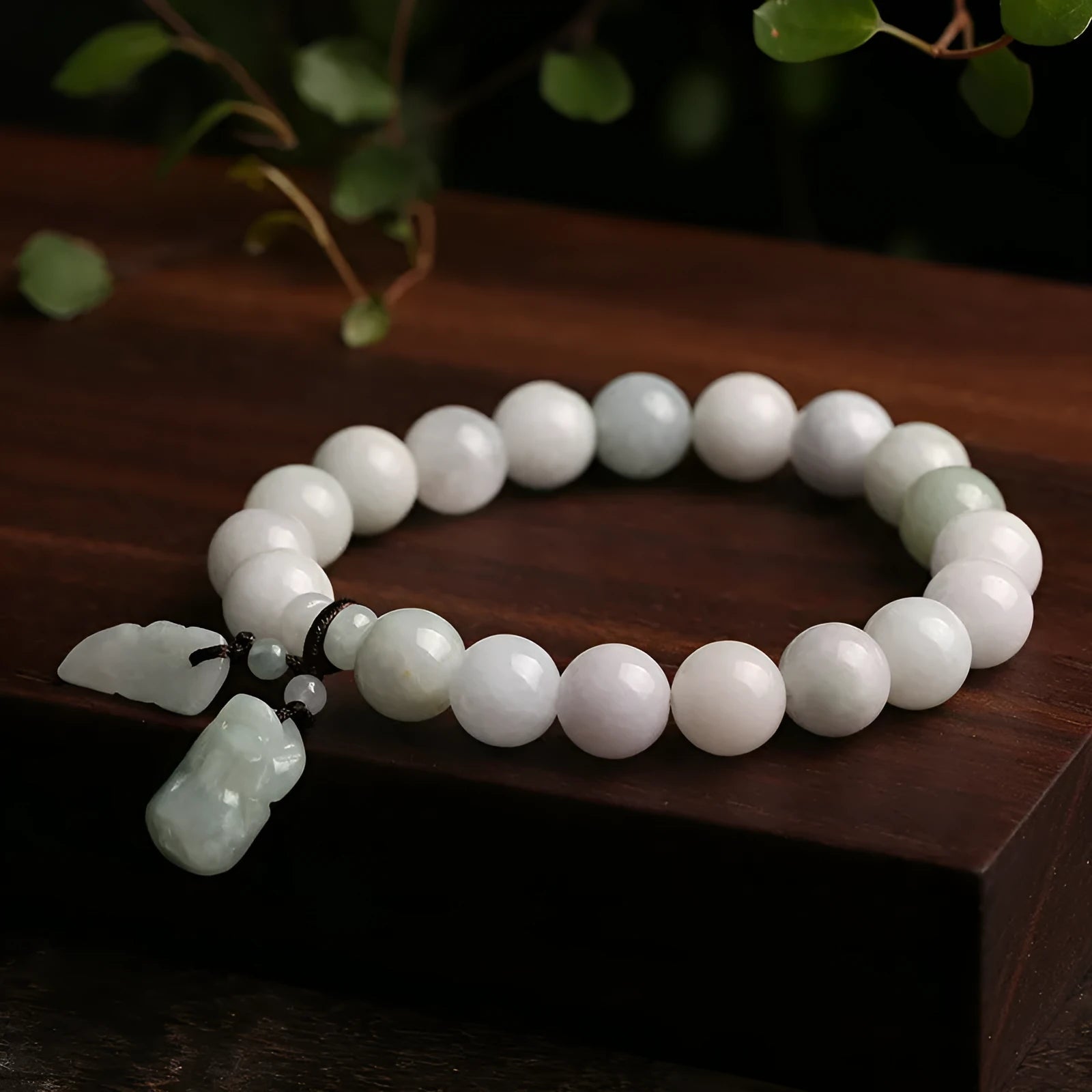 Natural green jade bracelet with Maitreya Buddha charm pendant on a wrist.