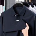 Man wearing a loose-fit grey cotton polo shirt with an asymmetric design and long sleeves.