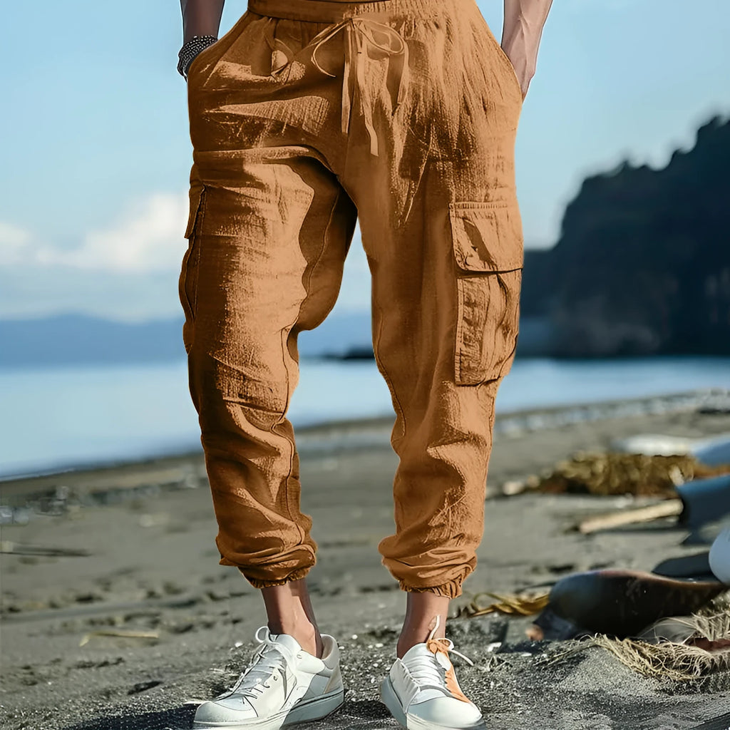 Men's solid colour linen casual trousers with ankle ties and drawstring waist on hanger.