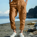 Men's solid colour linen casual trousers with ankle ties and drawstring waist on hanger.