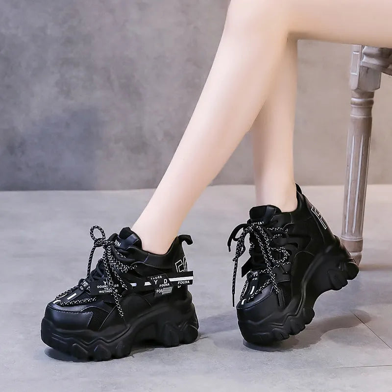 Women's white low-top platform tennis shoes with mesh upper and cross-strap detail on a rubber sole.