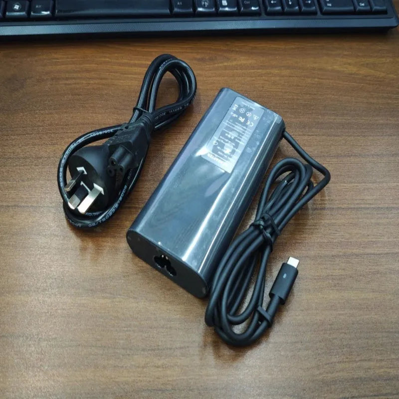 Black oval 65W Type-C laptop power adapter with international power cords