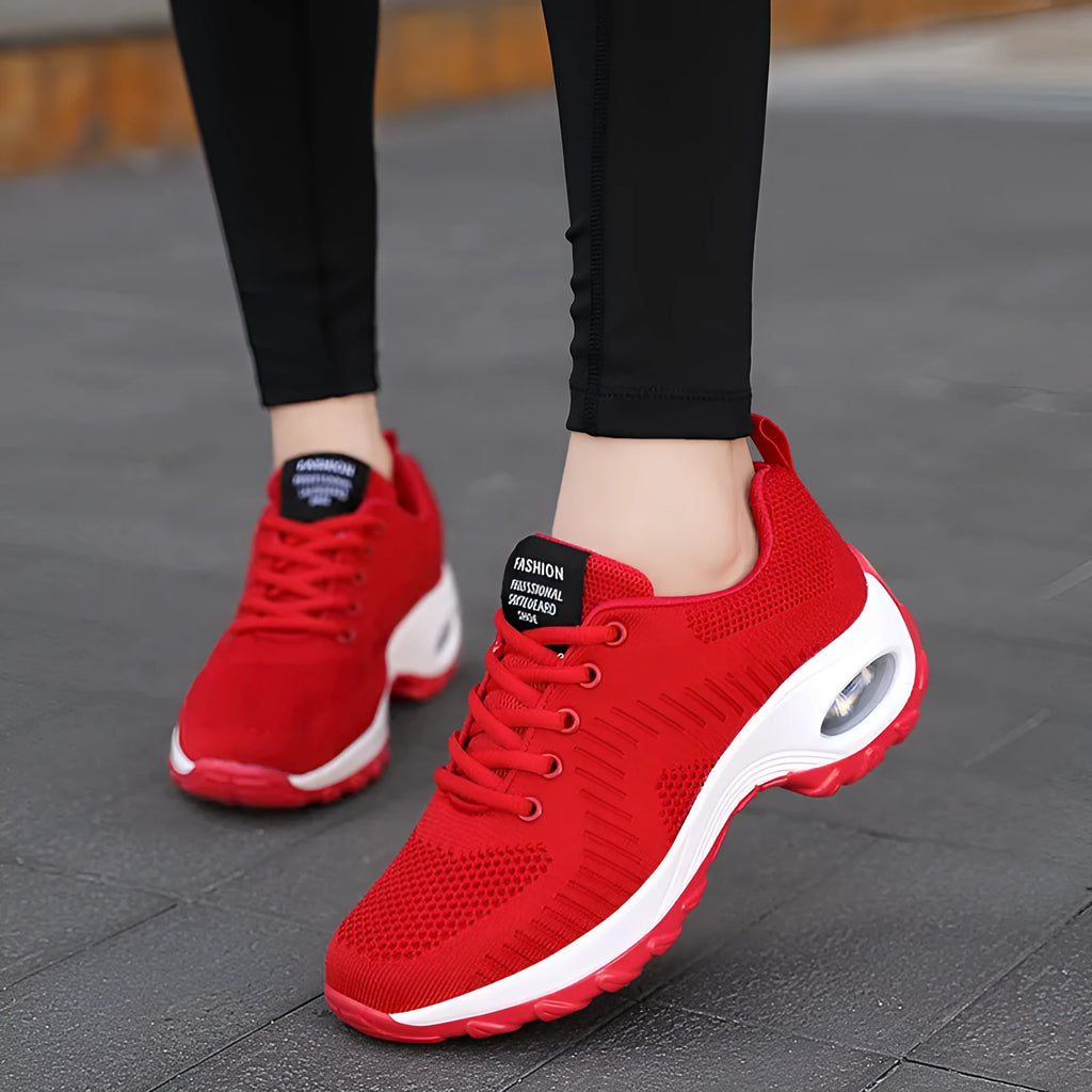 Women's red mesh sneakers with round toe and front lace-up design on flat surface