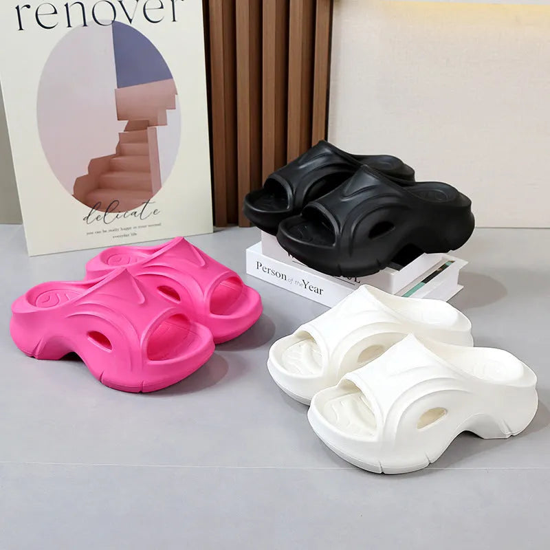 Women's white thick-soled EVA beach slippers with round toe, shown on a sandy background.