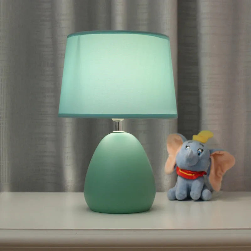 Small Nordic minimalist ceramic desk lamp in pink with LED light on desk
