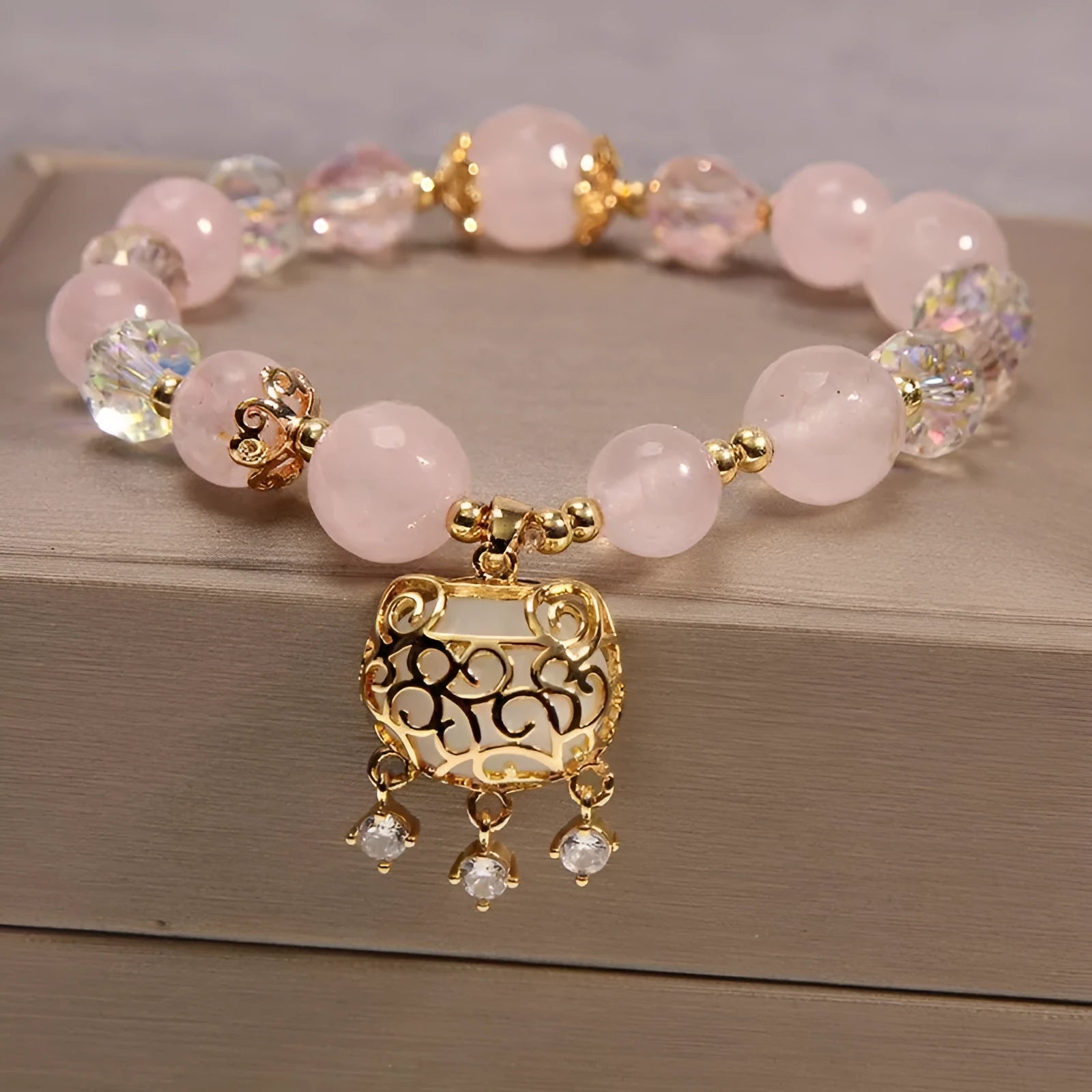 Khaki coloured crystal beads on a gold silk string bracelet, showing adjustable closure.