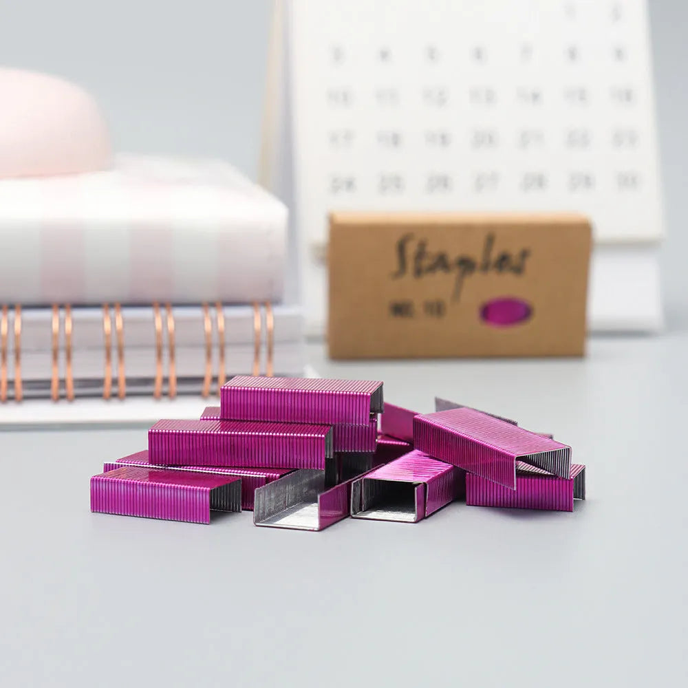 A box of 1000 metal office staples in rose gold, black, purple, and rose red colour options.