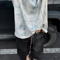 Man modelling a loose-fit, short-sleeved T-shirt with a blue and white tie-dye print pattern.